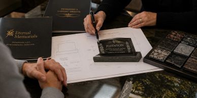 People designing a grave headstone with samples and sketches.