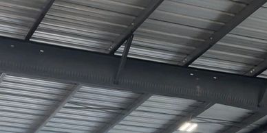 Ceiling structure with metal beams and lighting fixtures.