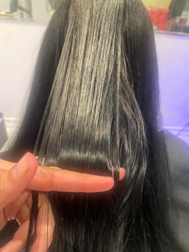 Finger measuring the length of wet hair.