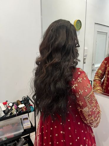 Woman with long curly hair in red traditional dress.