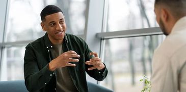 Two men engaged in a conversation indoors.