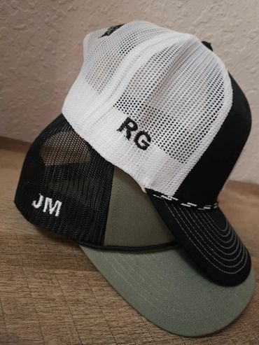 Two personalized baseball caps with initials RG and JM.