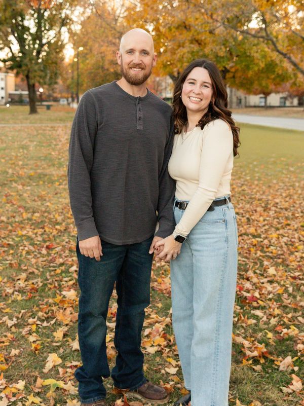 A happy couple holding hands outdoors in autumn.