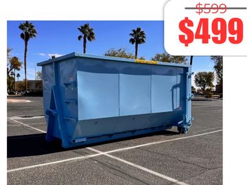 Large blue dumpster for sale at $499 in an empty parking lot.
