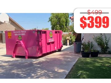 Bright pink dumpster rental on driveway with price tag $399, discounted from $499.