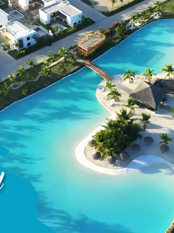 Aerial view of Primavera Residences IV with a large blue lagoon and modern white houses.