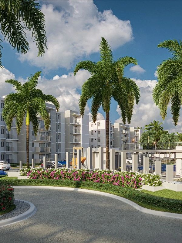 Condominio moderno con palmeras y área verde.