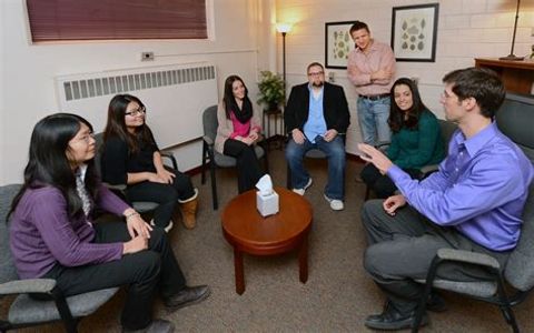 A group of six people in a casual meeting sitting in a circle.