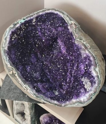 Large purple amethyst geode with crystalline interior.
