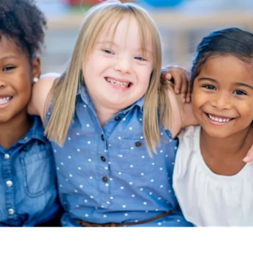 Three smiling girls hugging each other.