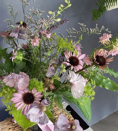 hand delivered bouquet of fresh pale pink and violet flowers at the doorstep