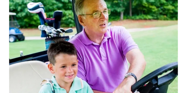 A grandfather and grandson sitting together in a golf cart