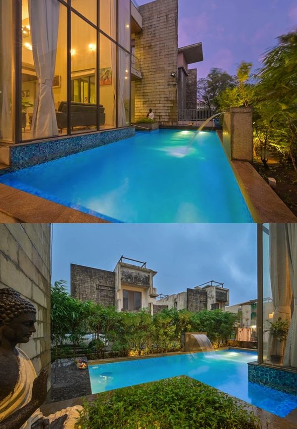 Modern house with a glowing blue swimming pool at dusk and surrounding greenery.