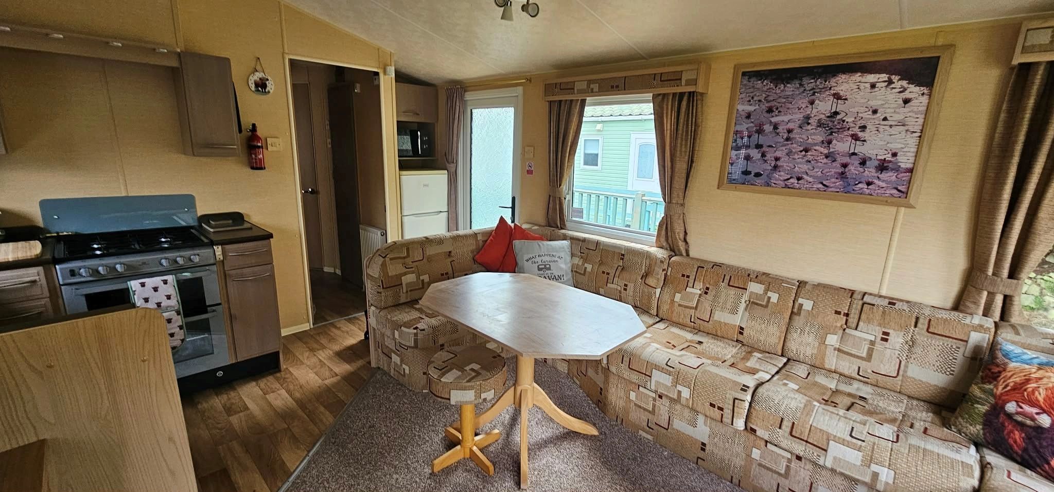 Cozy living area with patterned sofa and kitchen in a compact space.