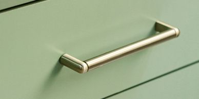 Representative cabinet handle on a sage-green drawer.