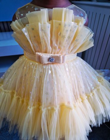 Elegant yellow frilly dress with star patterns.
