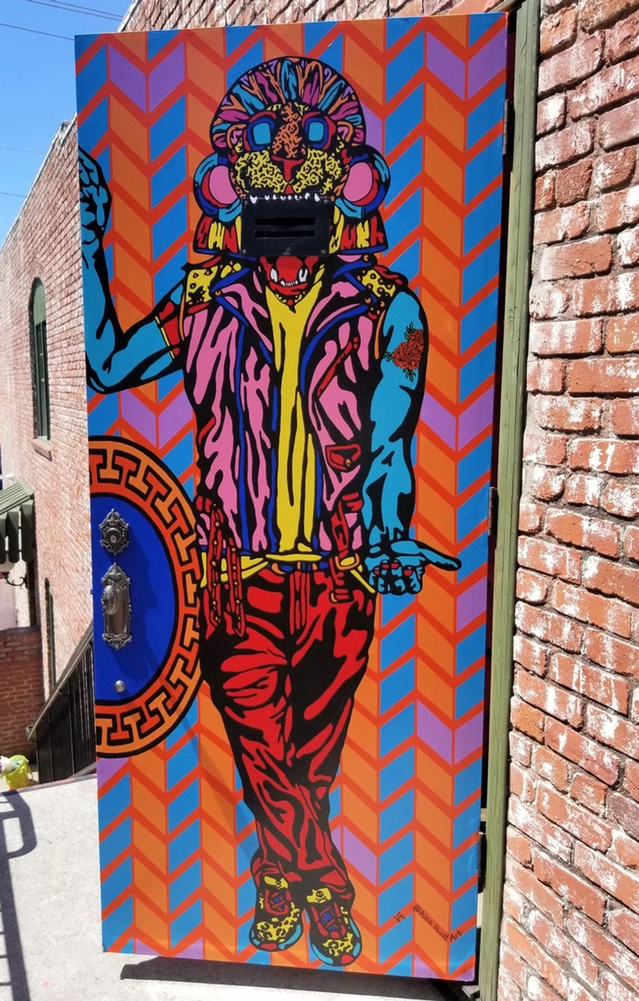 Colorful street art depicting a stylized figure with a leopard face.