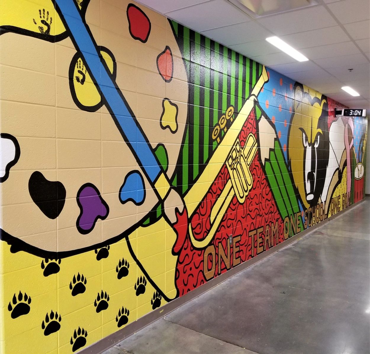 Colorful mural with musical and school themes on a hallway wall.