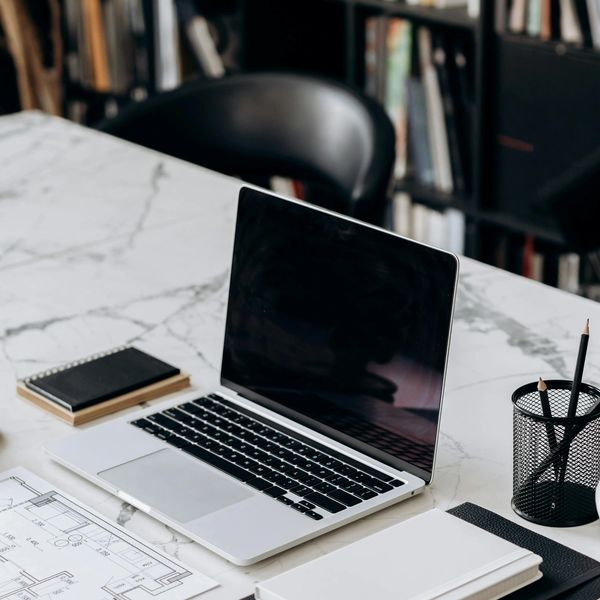 Laptop on a marble desk with a notebook and glasses, symbolizing professional remote notary services