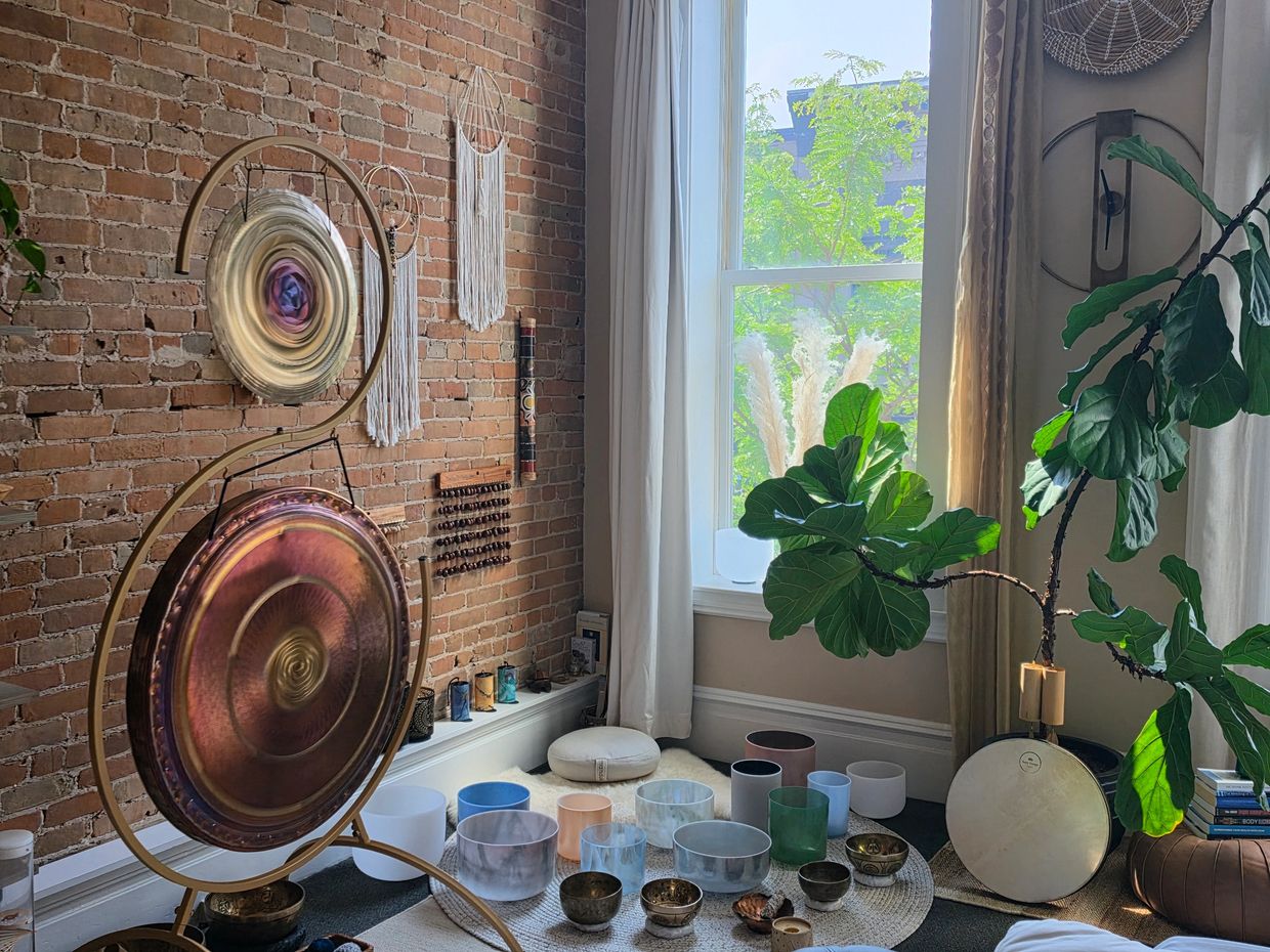 Cozy meditation corner with gongs and plants.