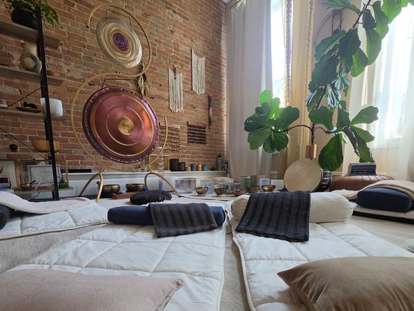 Cozy meditation space with cushions and gongs.