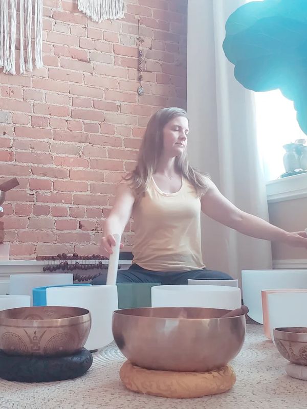 Sound Healing Practitioner playing crystal singing bowls