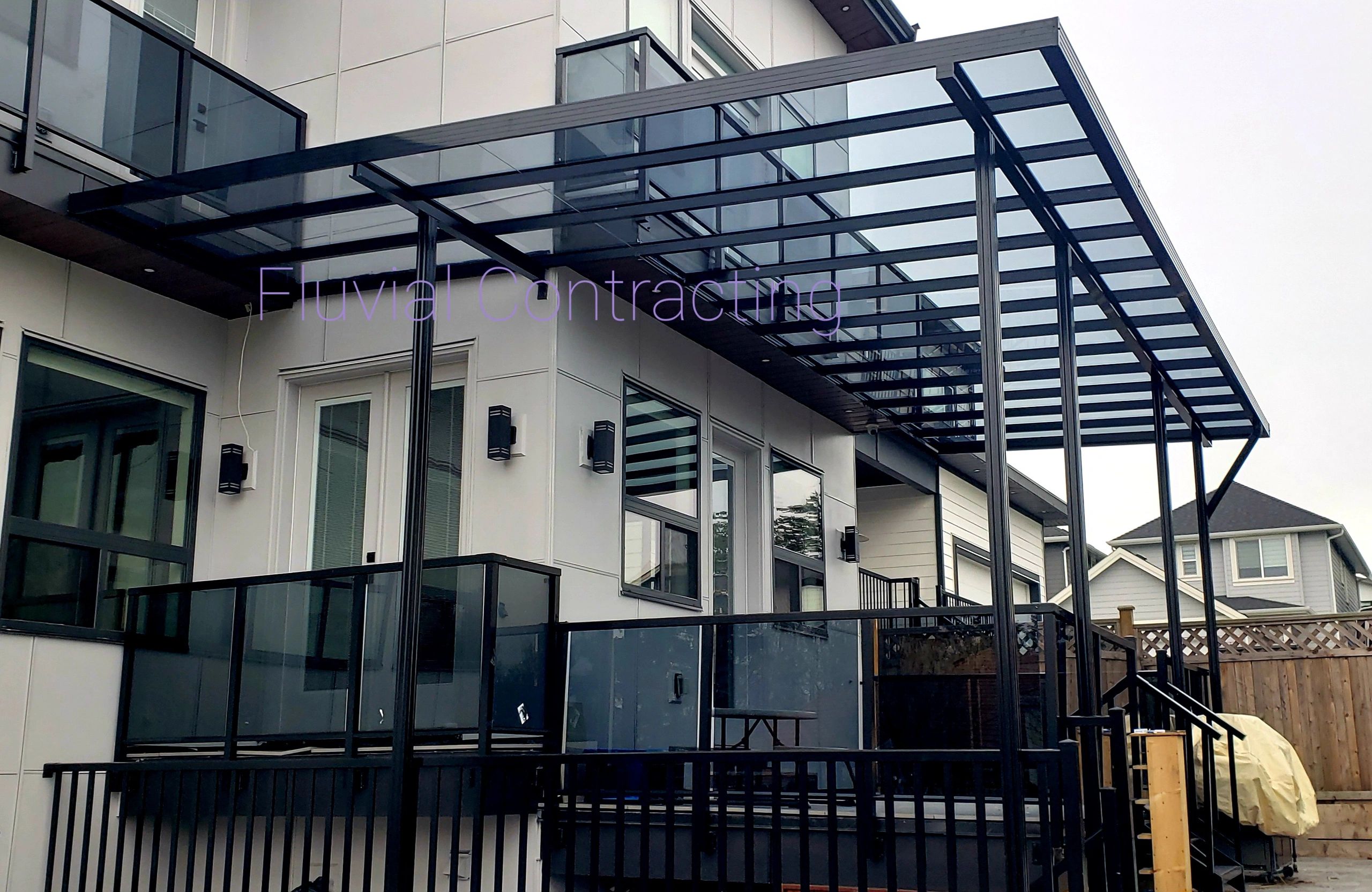 Modern black metal and glass patio cover on a residential house.