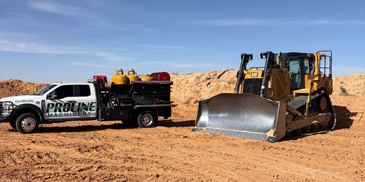 A Proline Machinery truck and a CAT bulldozer on a construction site.