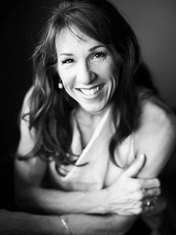 Black and white image of a confident woman smiling.