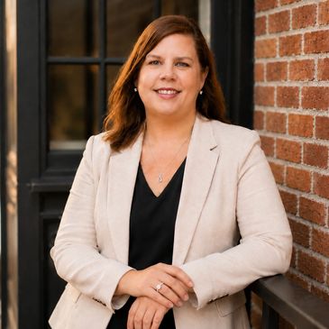Professional woman smiling in beige blazer.