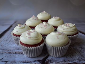 red velvet cupcakes with cream cheese frosting and pink sprinkles