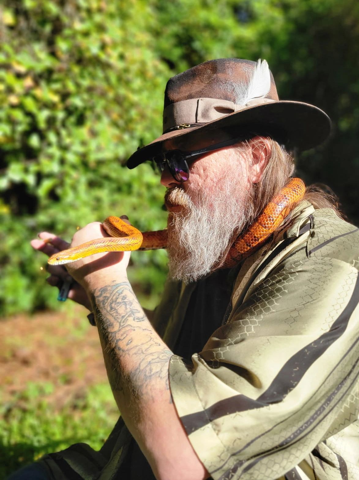 Bearded man with snake around neck.