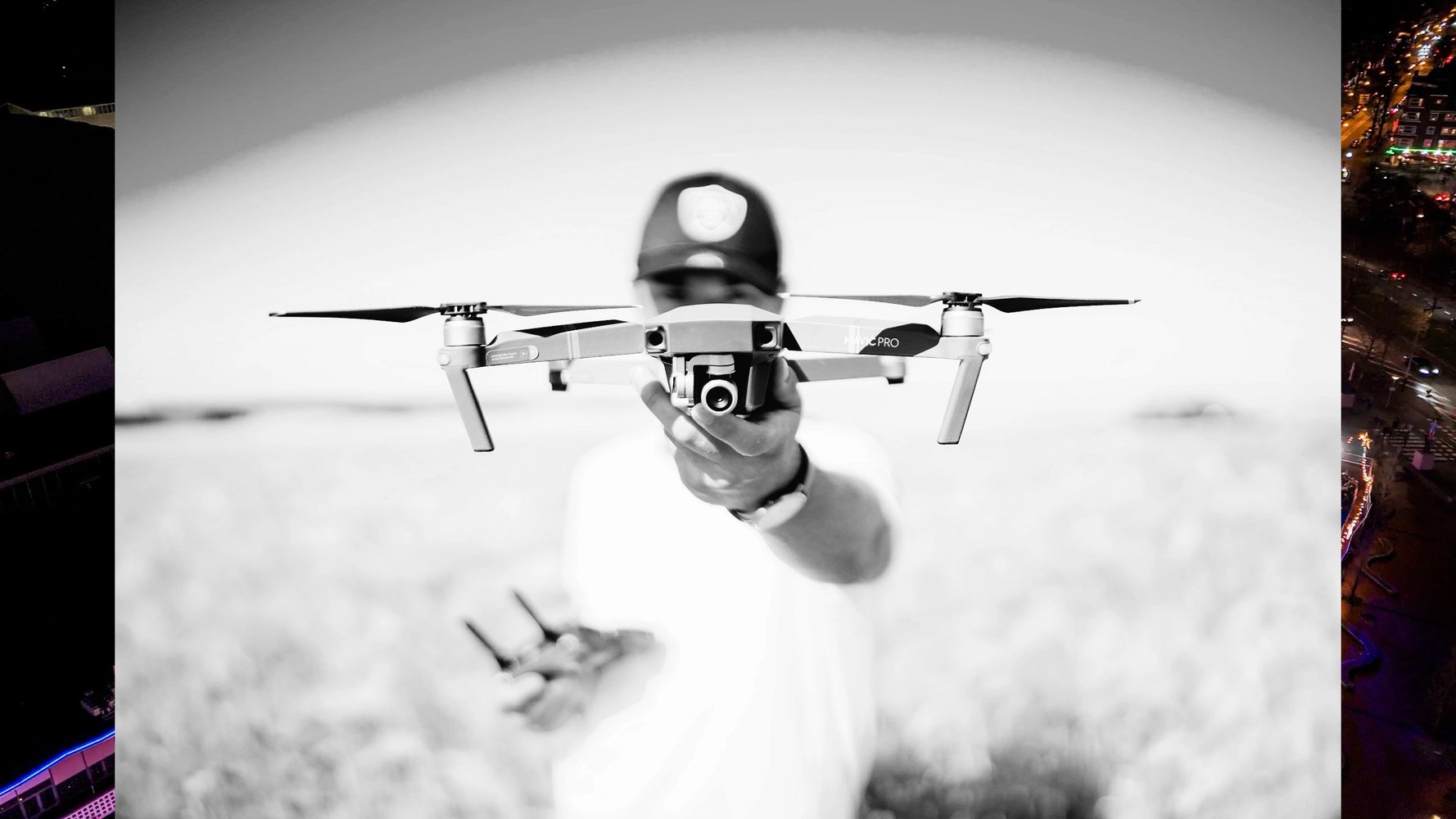 Person holding a hovering DJI Mavic Pro drone with a remote control in hand.