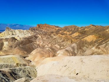 Colorful rocky hills under a clear blue sky in a desert landscape.