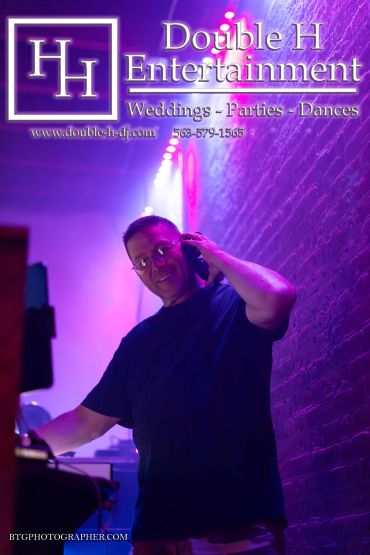 DJ playing music at a party with Double H Entertainment branding.