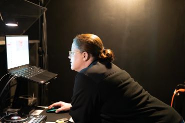 Person working on a laptop in a dimly lit room.