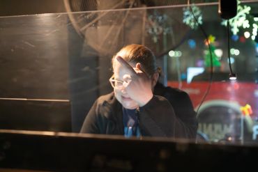 Person shielding eyes from bright light while working at night.