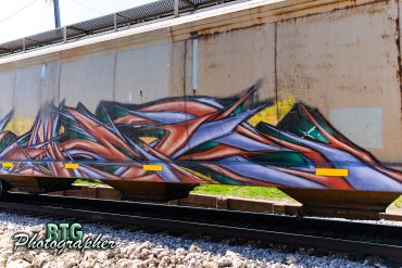 Colorful abstract graffiti on a train car with vibrant geometric shapes.