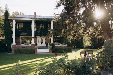 Elegant house with white columns bathed in warm sunlight.