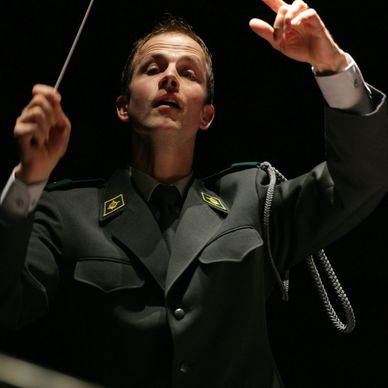 Dirigent in Uniform beim Dirigieren.