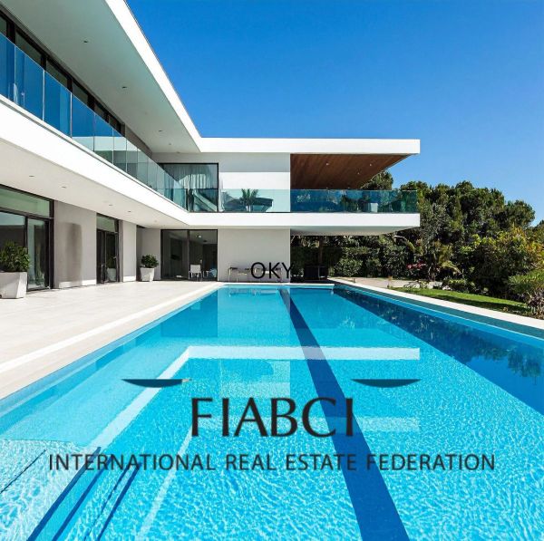 Modern house with a large swimming pool and FIABCI logo.