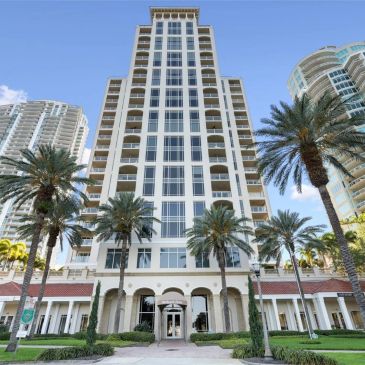 Tall residential building with palm trees in front.