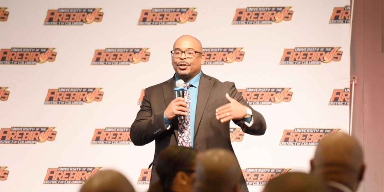 Man speaking at University of the Firebirds event.