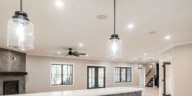 Spacious modern living room with pendant lights and large windows.