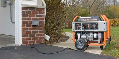Portable generator connected to a house during outdoor setup.