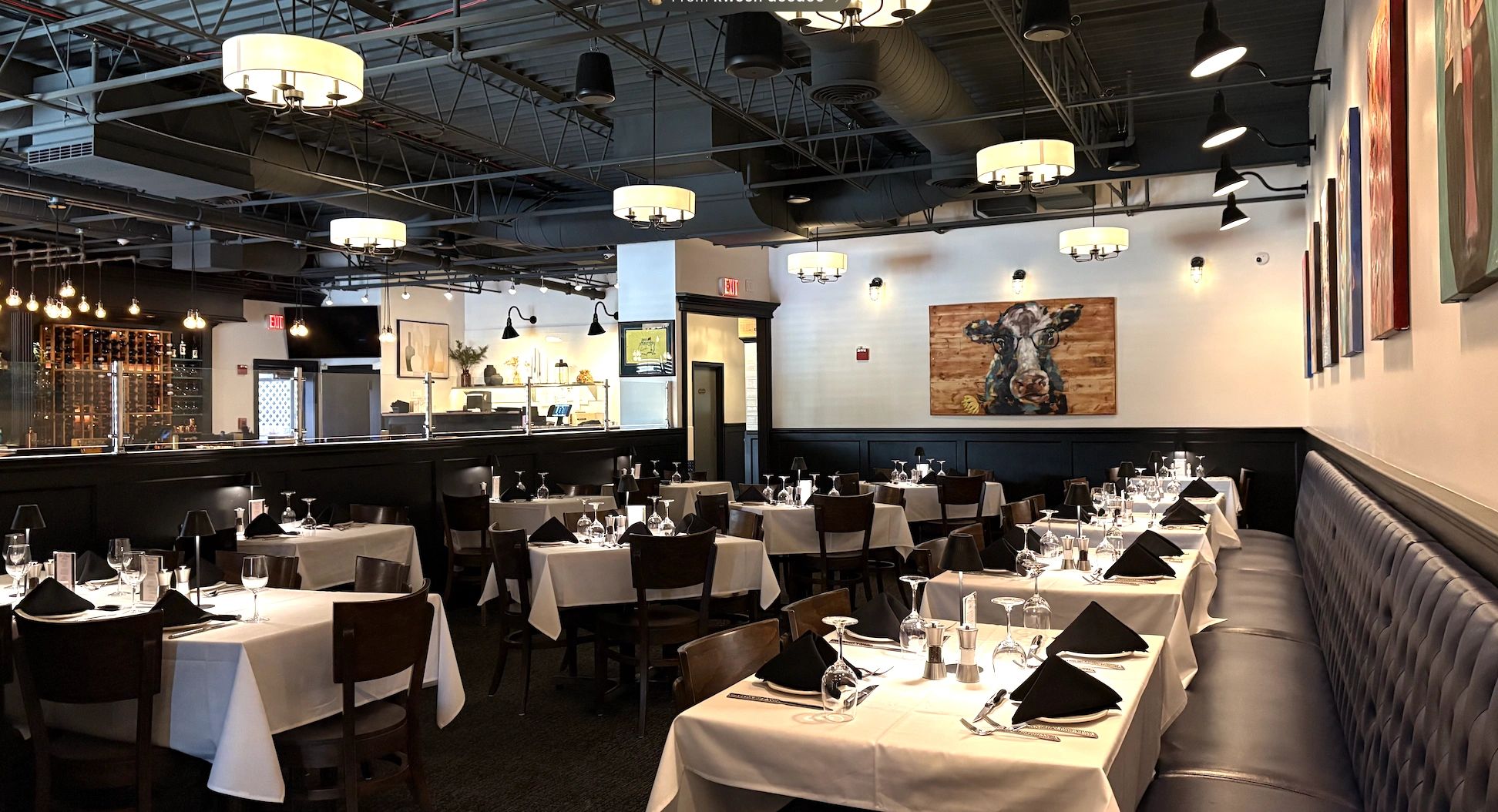 Elegant restaurant dining area with white tablecloths and modern lighting.