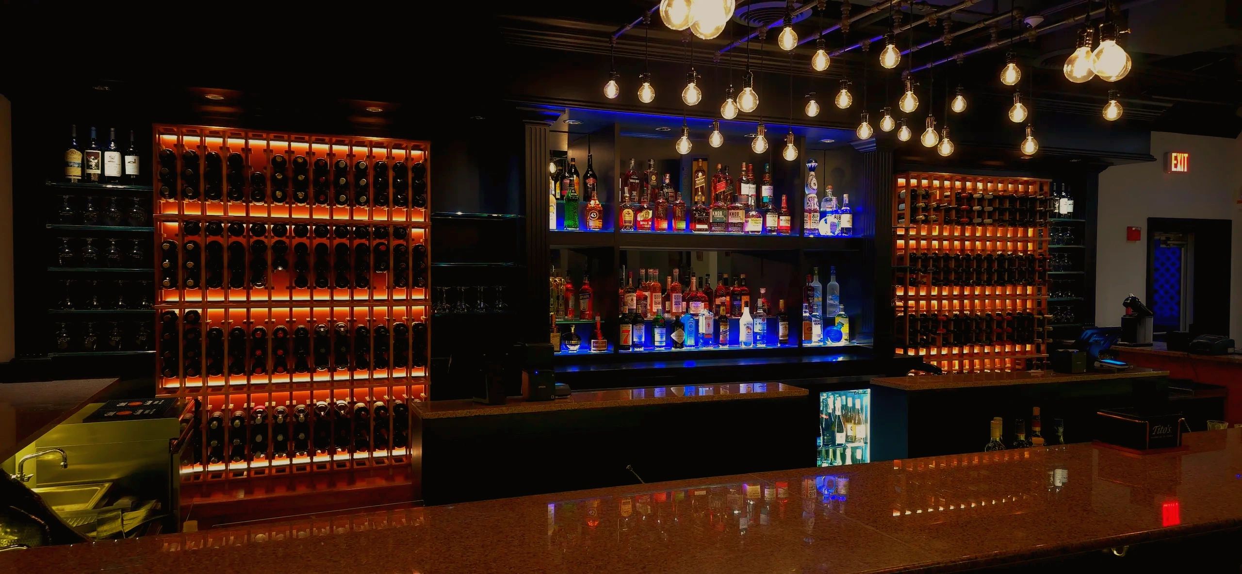 Modern bar with ambient lighting and liquor display.