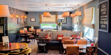 Cozy, well-lit dining area with mixed seating and decorative lamps.