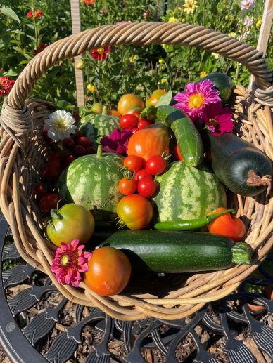 Basket of fresh garden vegetables and flowers.
