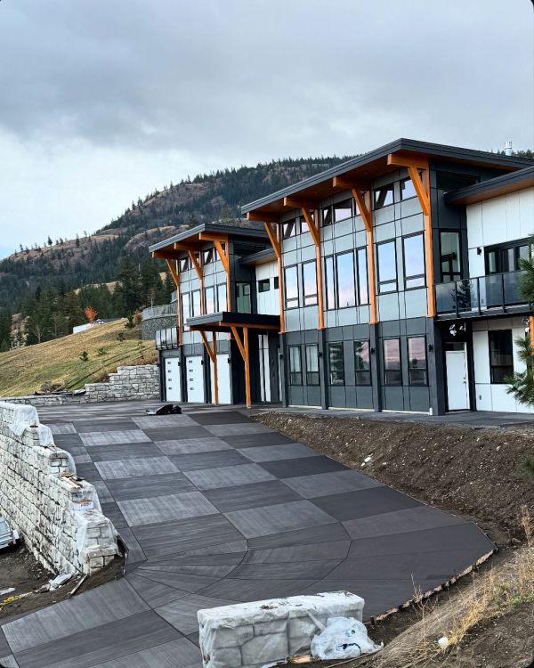 Modern building with large windows and mountain backdrop.